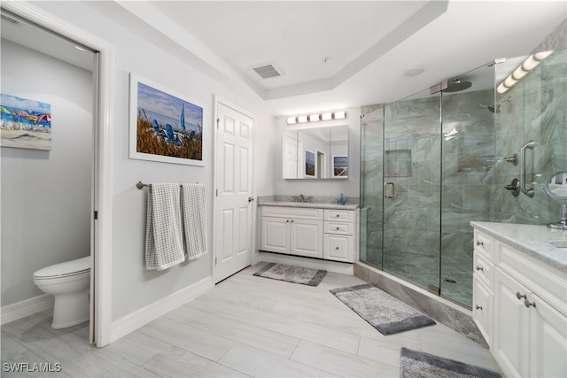 bathroom featuring vanity, toilet, and a shower with door