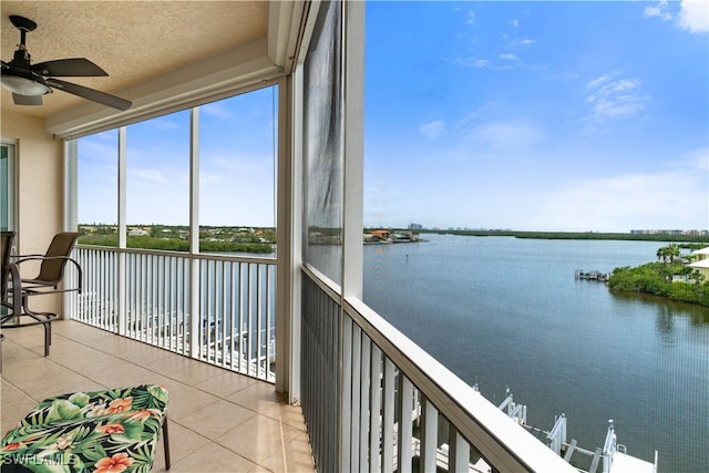 unfurnished sunroom featuring a water view and ceiling fan