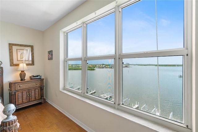 interior space with a water view, hardwood / wood-style flooring, and a healthy amount of sunlight