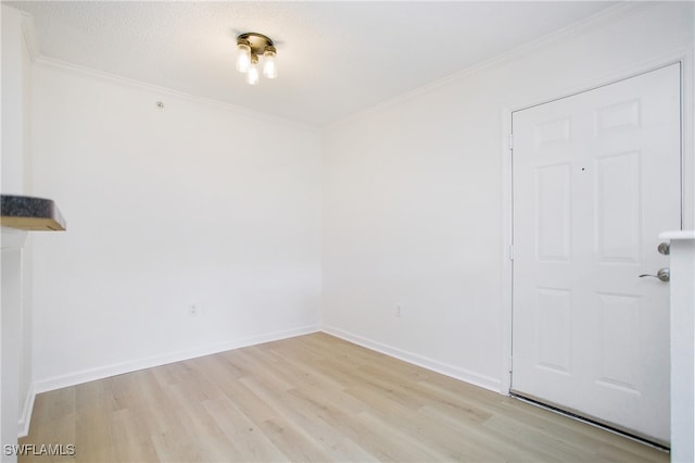 unfurnished room featuring crown molding, light wood-type flooring, and a textured ceiling