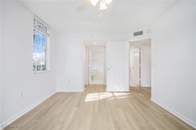 unfurnished bedroom featuring ceiling fan, connected bathroom, and light hardwood / wood-style flooring