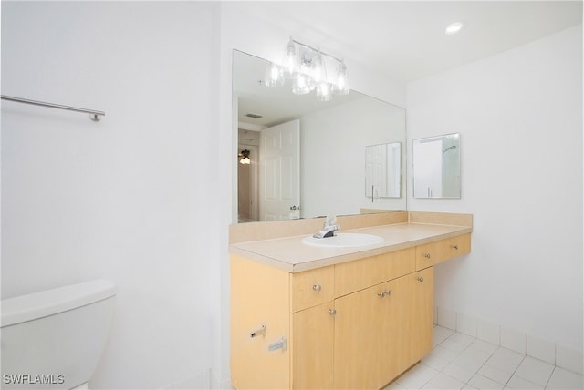 bathroom featuring vanity, tile patterned flooring, and toilet