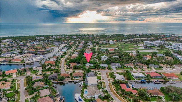 aerial view at dusk featuring a water view