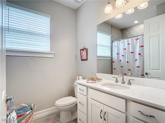 bathroom featuring hardwood / wood-style flooring, vanity, curtained shower, and toilet