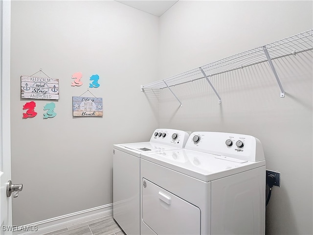 laundry room featuring light hardwood / wood-style floors and washer and clothes dryer