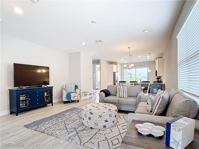 living room with a chandelier and light hardwood / wood-style flooring