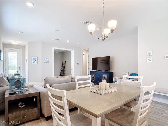 dining room featuring light wood-type flooring and a chandelier