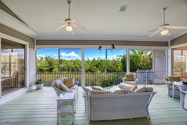 sunroom featuring lofted ceiling, ceiling fan, and a healthy amount of sunlight