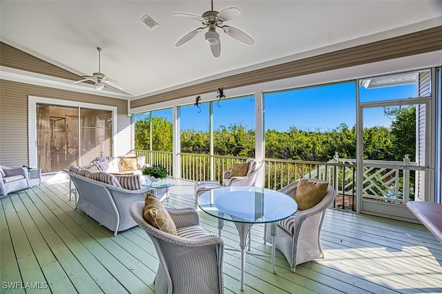 sunroom / solarium featuring ceiling fan, vaulted ceiling, and a healthy amount of sunlight