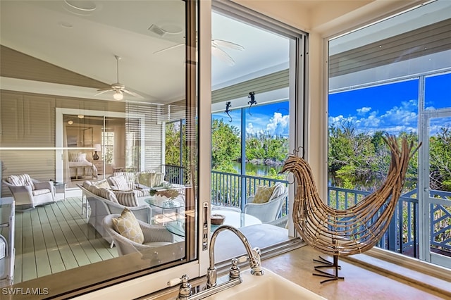 sunroom with ceiling fan and lofted ceiling