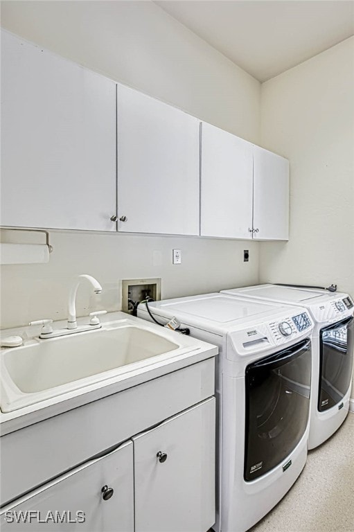 washroom featuring cabinets, sink, and washing machine and dryer