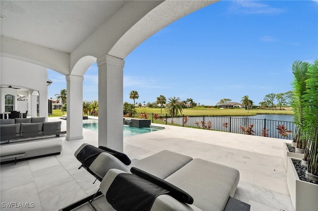 view of patio featuring a water view, an outdoor living space, and a fenced in pool