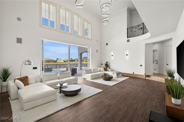 living room with hardwood / wood-style floors and a towering ceiling