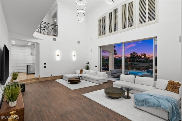 living room featuring a towering ceiling and hardwood / wood-style floors