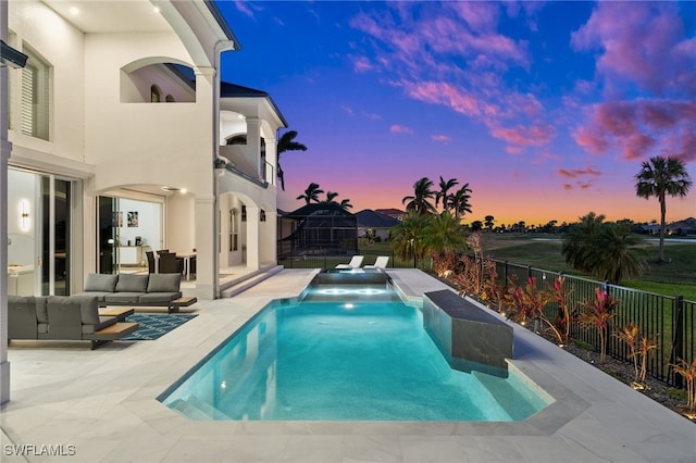 pool at dusk featuring an outdoor living space and a patio