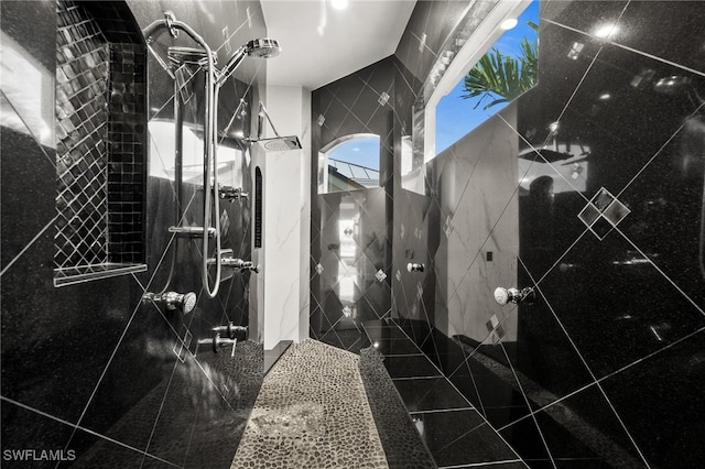 bathroom featuring tiled shower and tile walls