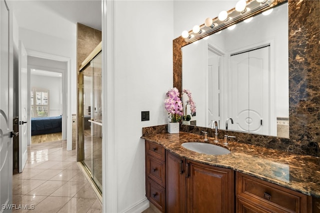 bathroom featuring vanity, tile patterned floors, and a shower with door