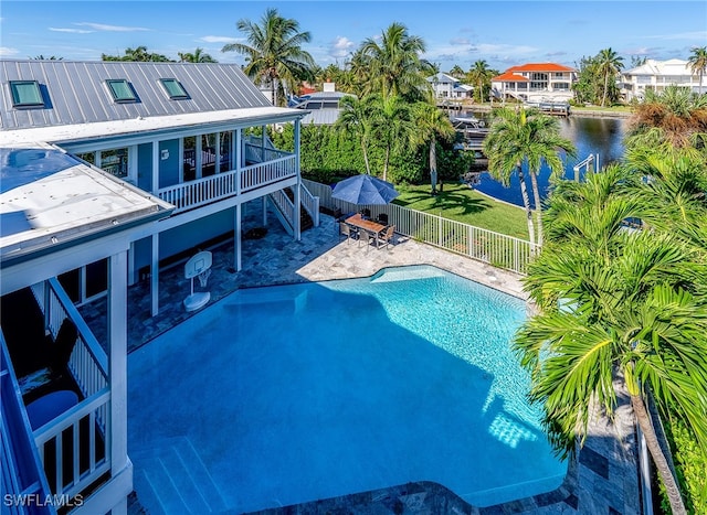 view of pool with a patio and a water view