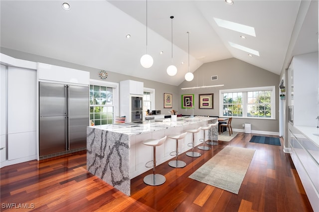 kitchen featuring a spacious island, dark wood-type flooring, white cabinetry, and appliances with stainless steel finishes