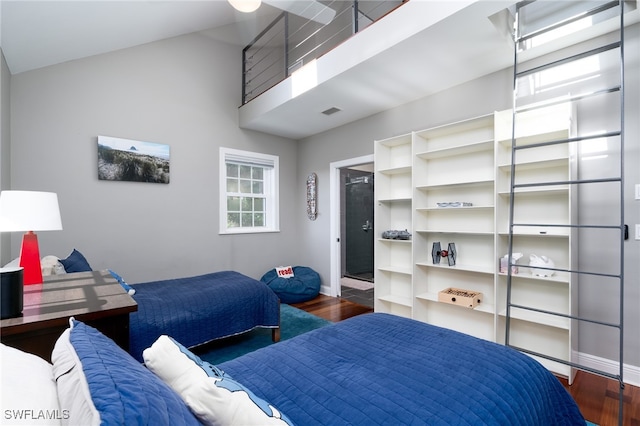 bedroom featuring dark wood-type flooring and vaulted ceiling