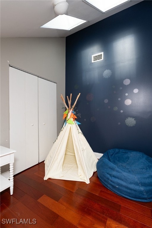 playroom featuring lofted ceiling and hardwood / wood-style floors