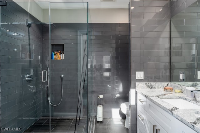 bathroom with vanity, tile patterned floors, toilet, and an enclosed shower