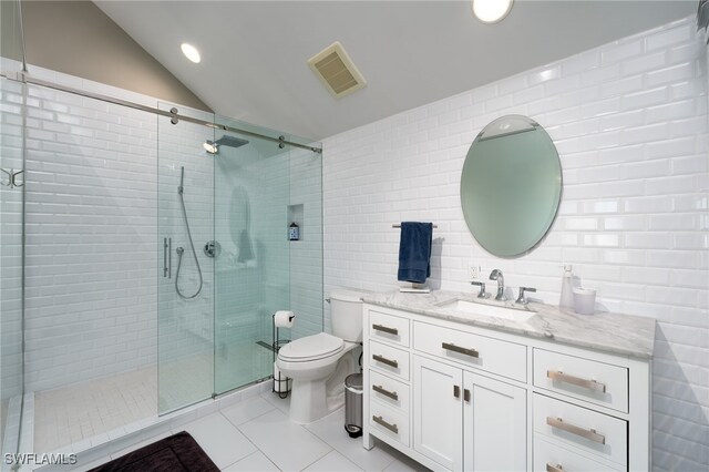 bathroom featuring a shower with door, vanity, vaulted ceiling, and toilet