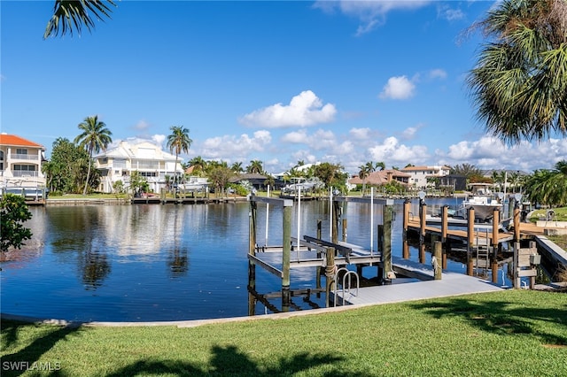 view of dock with a yard and a water view