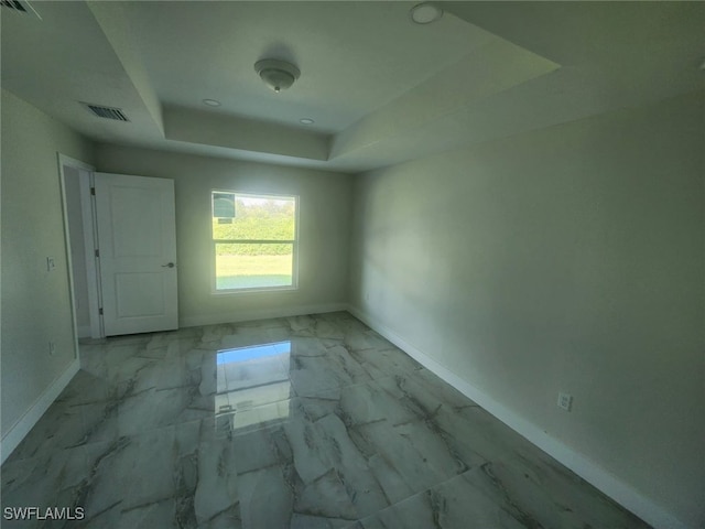 spare room with a raised ceiling