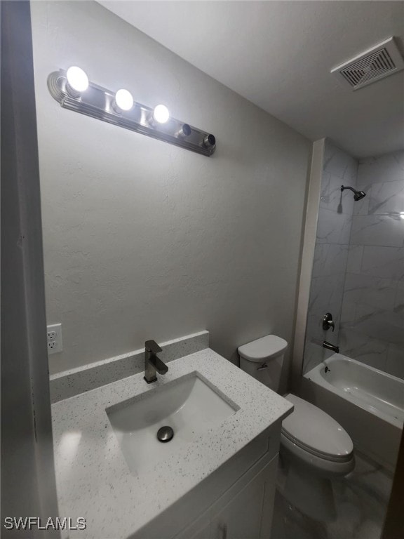 full bathroom with tiled shower / bath, vanity, and toilet