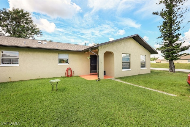 rear view of house featuring a lawn and a patio area