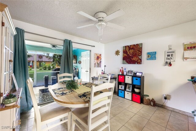 dining space with ceiling fan, a textured ceiling, and light tile patterned flooring