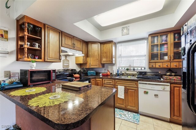 kitchen with dishwasher, black range with electric cooktop, a raised ceiling, and kitchen peninsula