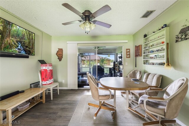 dining space featuring a textured ceiling, dark wood-type flooring, and a wealth of natural light