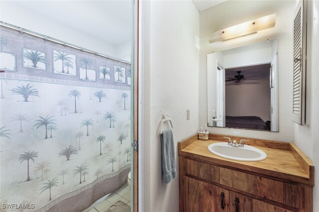 bathroom featuring ceiling fan, vanity, toilet, and curtained shower