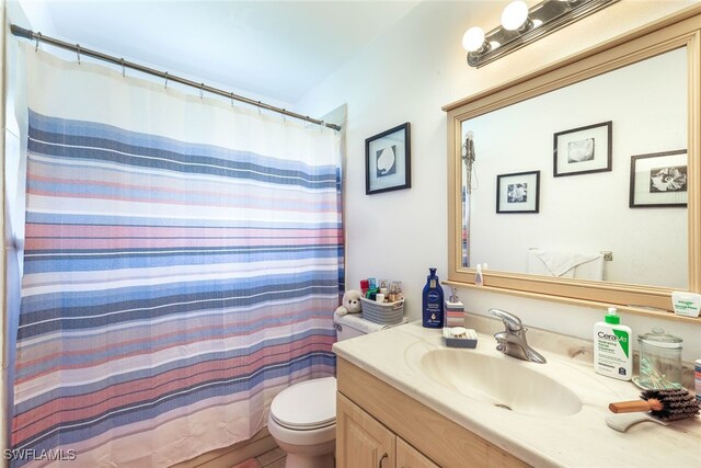 bathroom with a shower with curtain, vanity, and toilet