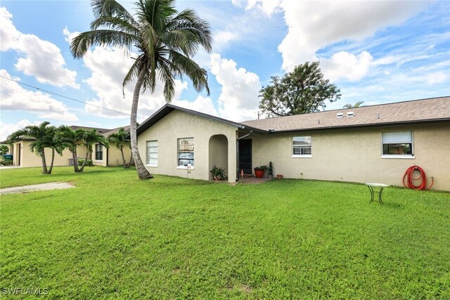 rear view of property with a yard