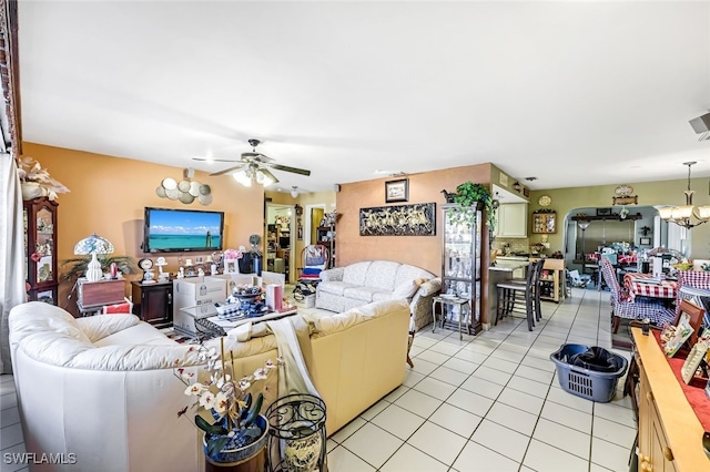 tiled living room featuring ceiling fan with notable chandelier