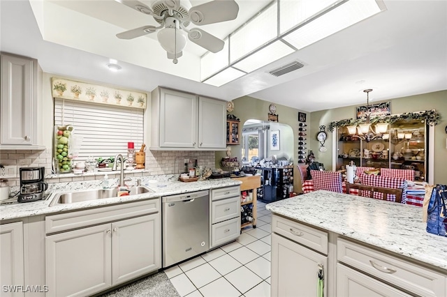 kitchen featuring decorative backsplash, stainless steel dishwasher, ceiling fan, and sink