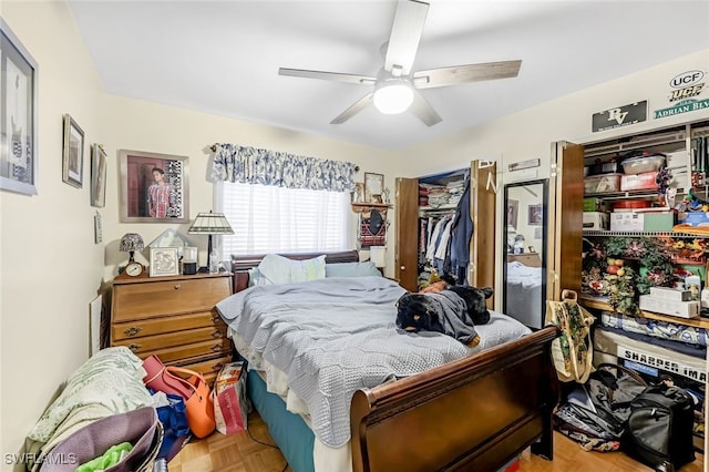 bedroom featuring ceiling fan, a closet, and parquet flooring