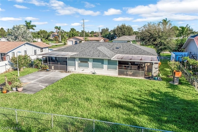 back of property with a patio area, a sunroom, and a yard