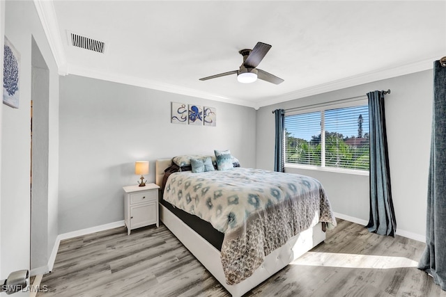 bedroom featuring crown molding, light hardwood / wood-style floors, and ceiling fan