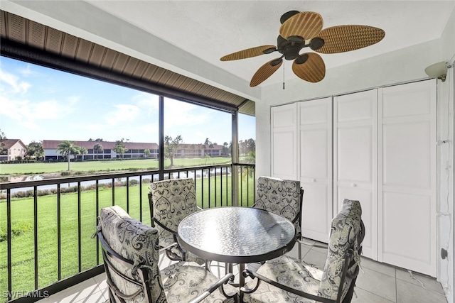 sunroom featuring a water view