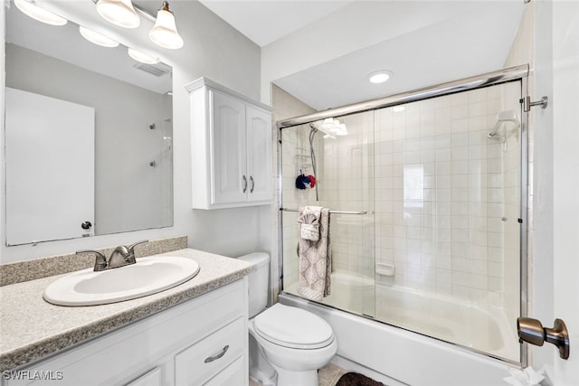 full bathroom with enclosed tub / shower combo, visible vents, vanity, and toilet