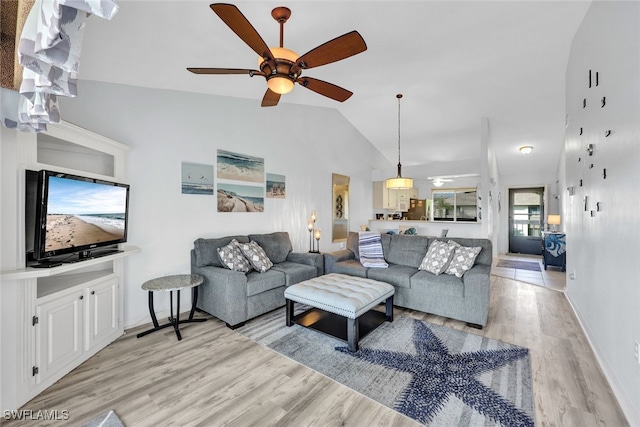 living room with ceiling fan, light wood-type flooring, and vaulted ceiling