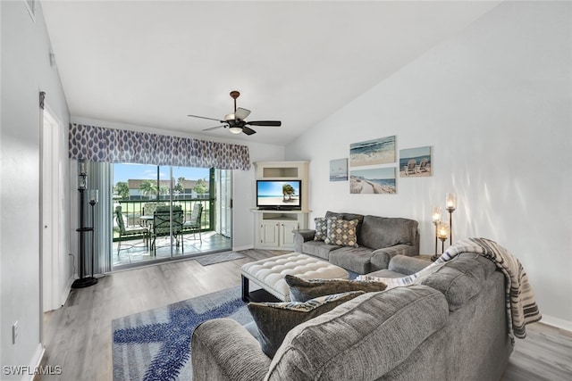 living room featuring vaulted ceiling, a ceiling fan, light wood-style floors, and baseboards