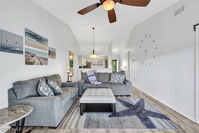 living room with baseboards, visible vents, lofted ceiling, ceiling fan, and wood finished floors