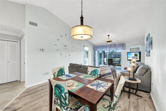 dining space featuring light wood-type flooring, vaulted ceiling, and baseboards