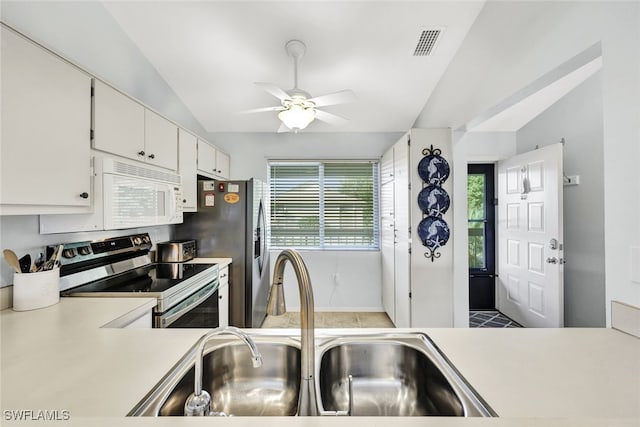 kitchen featuring lofted ceiling, light countertops, visible vents, a sink, and appliances with stainless steel finishes