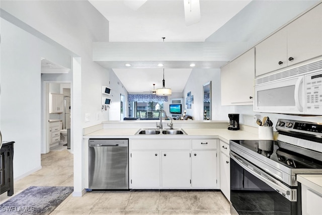 kitchen with stainless steel appliances, a sink, white cabinetry, vaulted ceiling, and light countertops